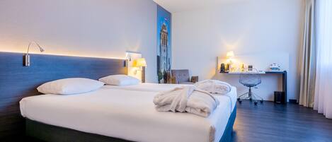 Una habitación de hotel con una cama grande, un escritorio y una silla.