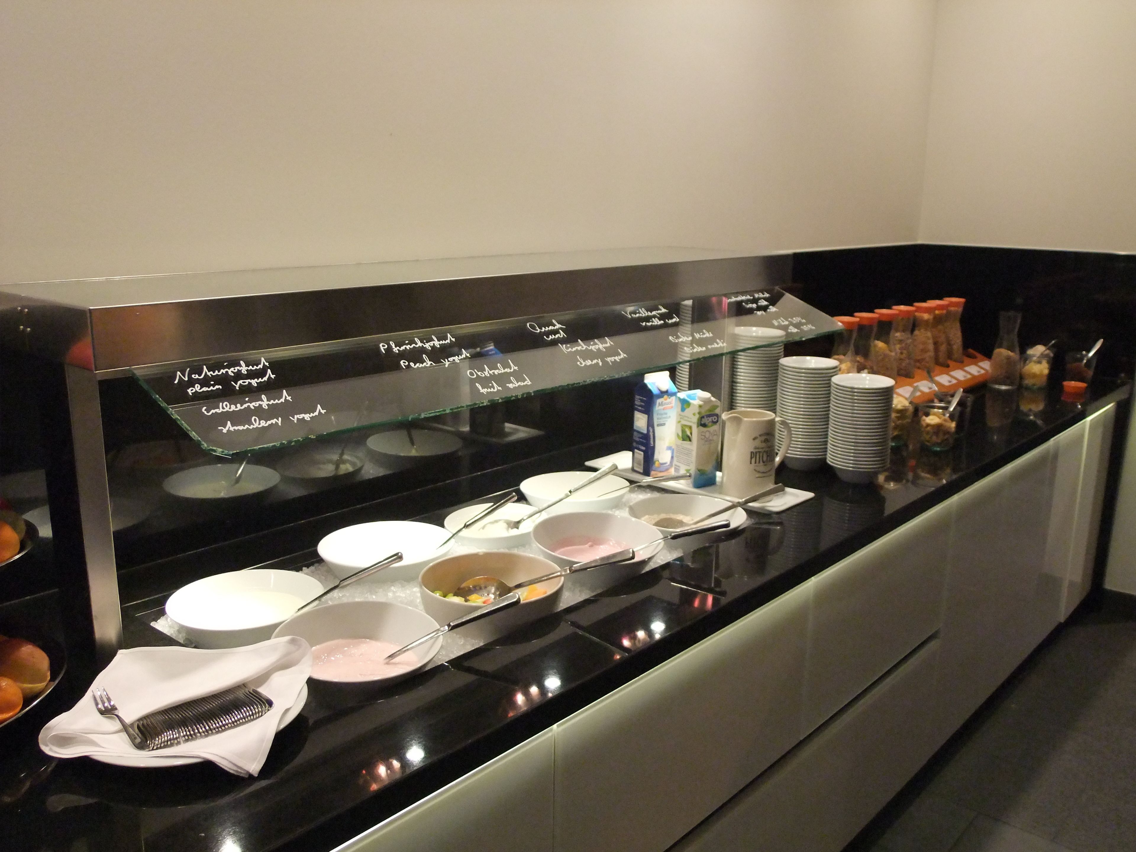 A buffet setup with various food items and utensils.