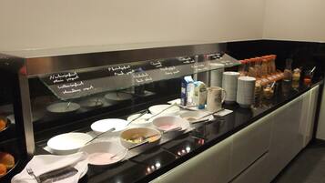 A buffet setup with various food items and utensils.