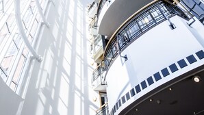 A multi-level atrium with a curved ceiling, glass railings, and a central open space.