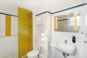 Un baño moderno con inodoro, lavamanos y ducha.