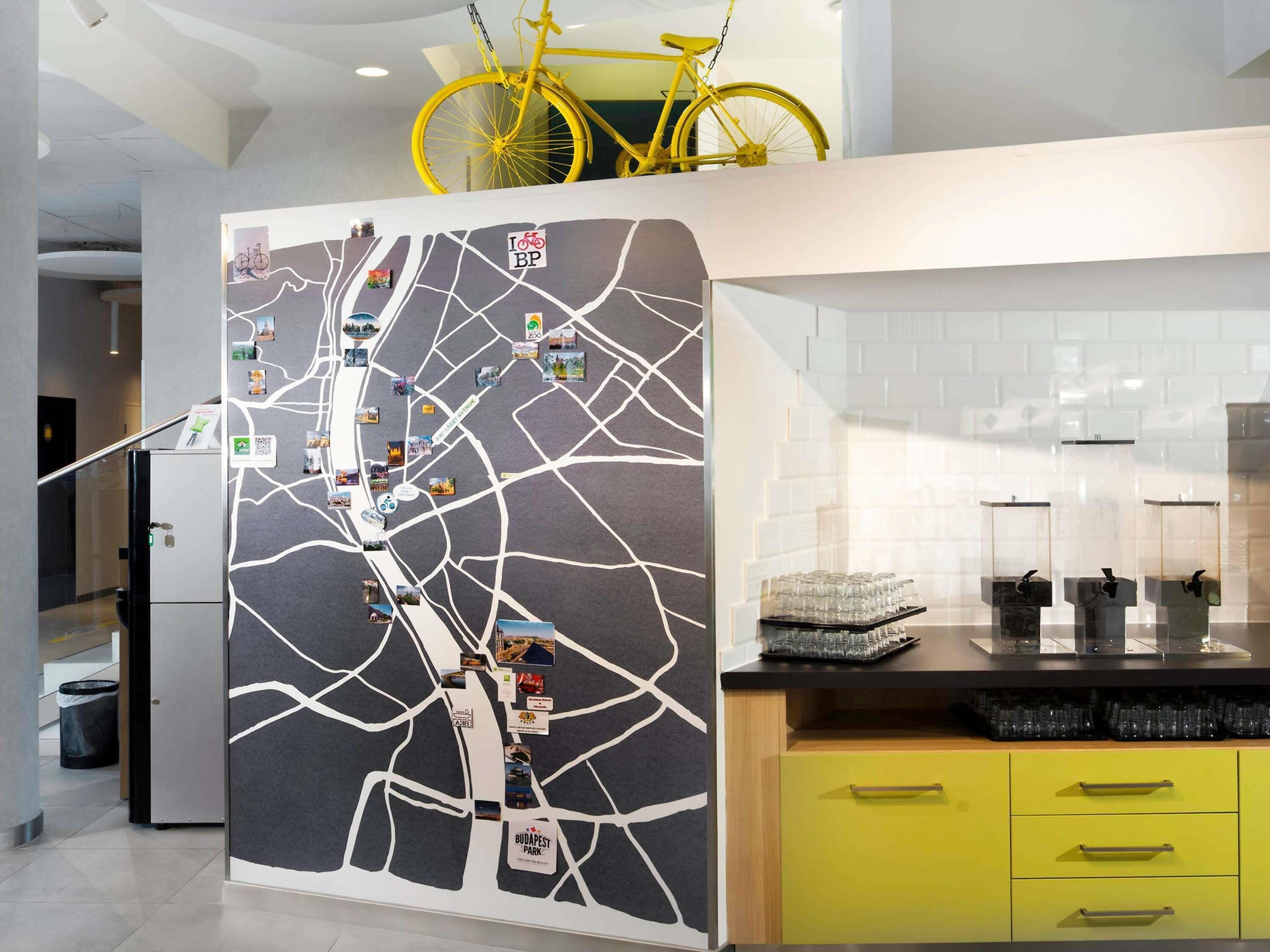 A modern kitchen with a map wall, a yellow bicycle, and a glass display case.