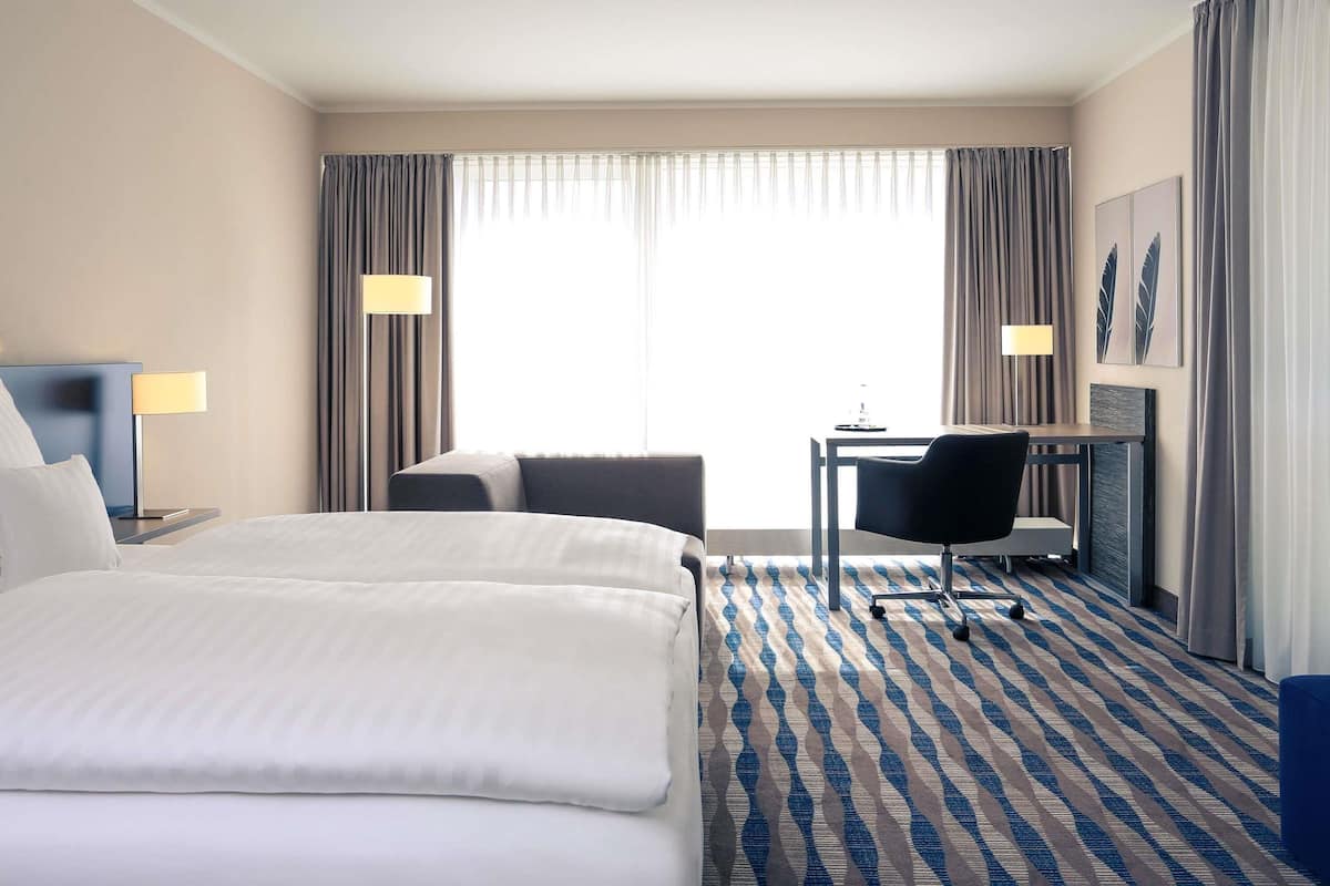 Ropa de cama hipoalergénica y caja de seguridad en la habitación