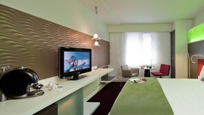 A hotel room with a bed, a TV, a desk, and a chair. - Mercure Paris La Défense Grande Arche (Nanterre)
