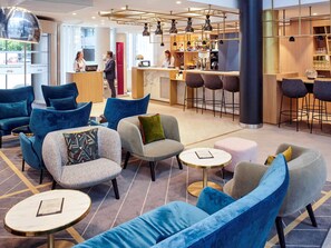Relax in our stylish lobby, featuring comfortable seating areas, a reception desk, and a bar with a selection of beverages.