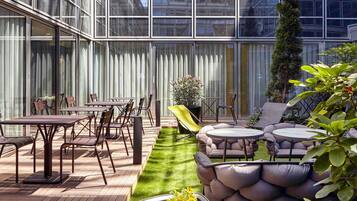 Eine moderne Außenpatio mit Essbereich, Sitzgelegenheiten und einem kleinen Garten.