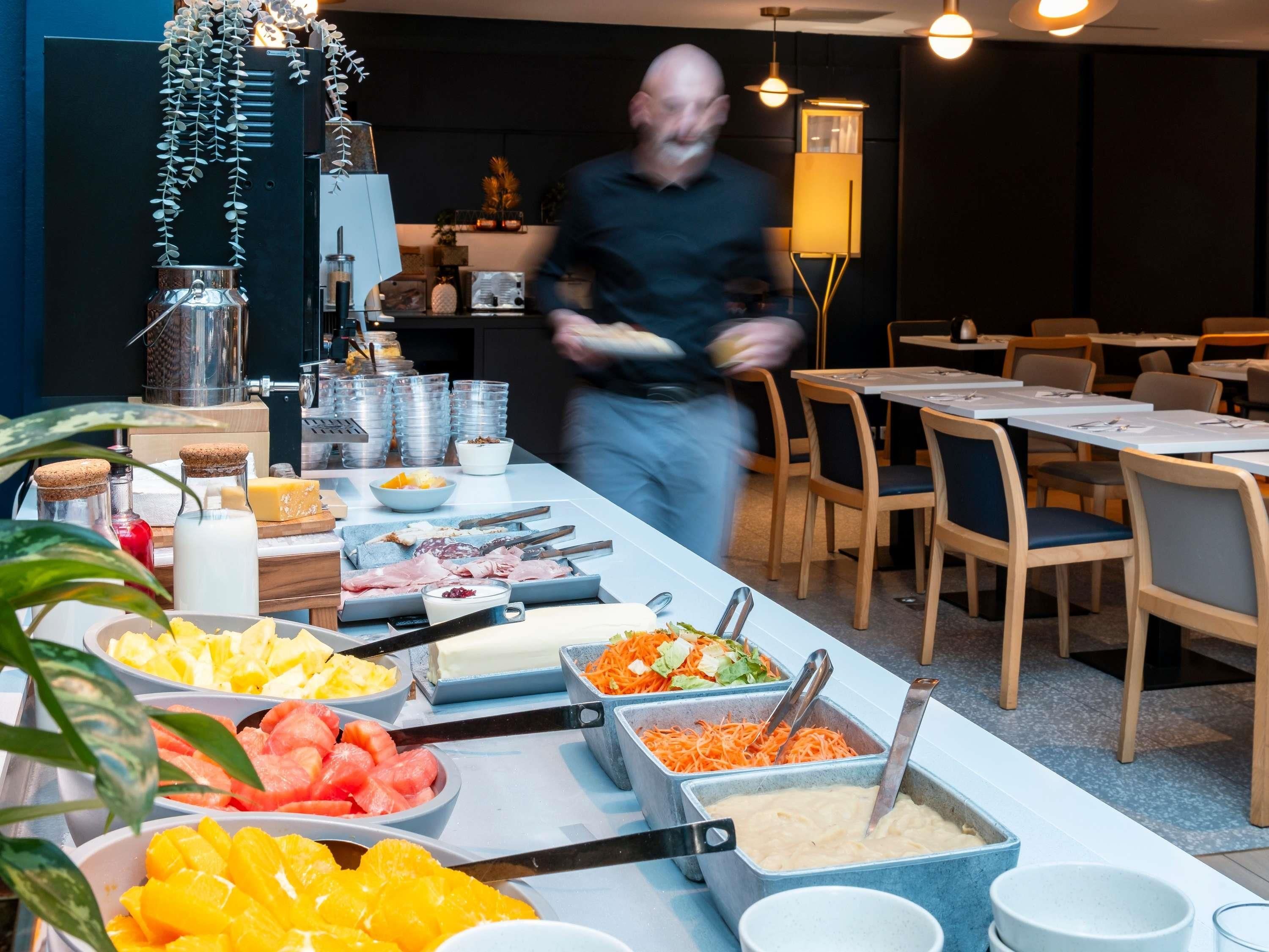 Un buffet proposant une variété de plats et une personne qui sert les clients.