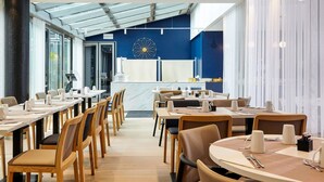 Un espace repas moderne avec de longues tables, des chaises et un comptoir central.