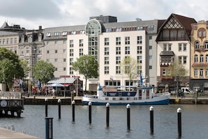 A riverfront with a historic building, a dock, and a boat.