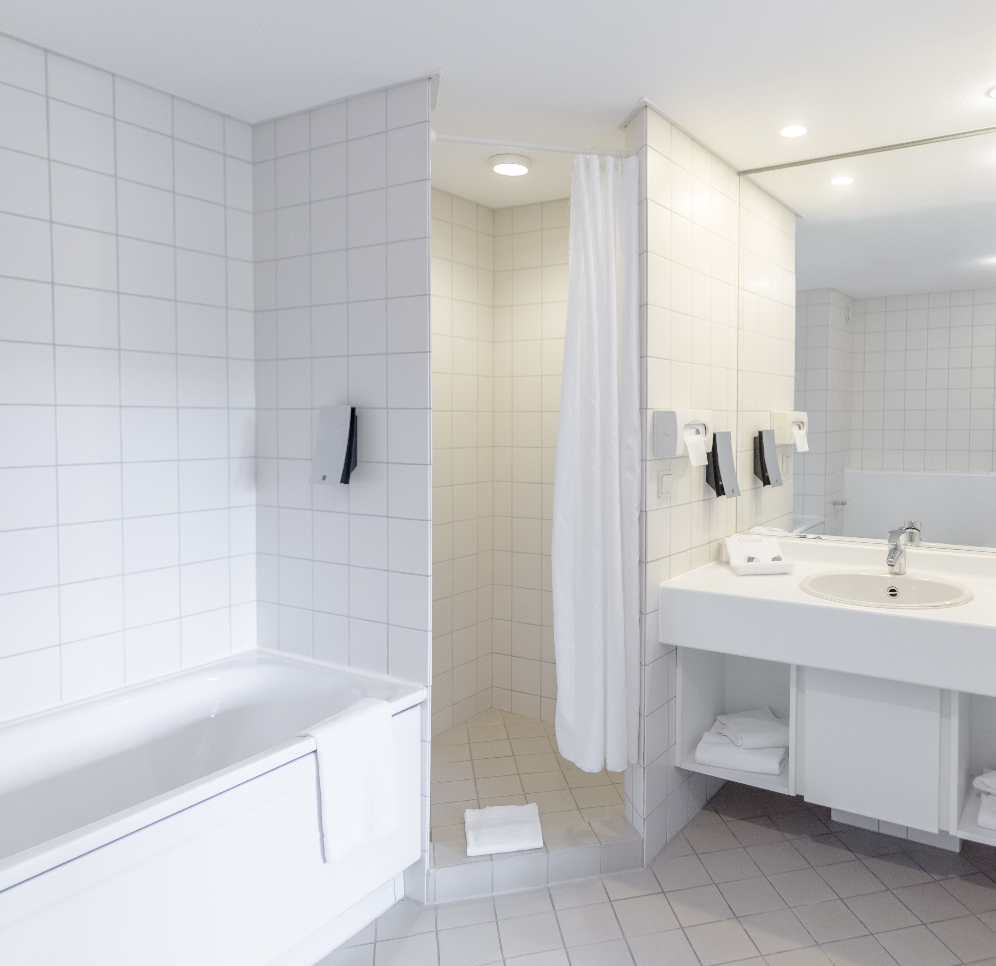 Une salle de bain moderne équipée d’une baignoire, d’une douche et d’un lavabo.