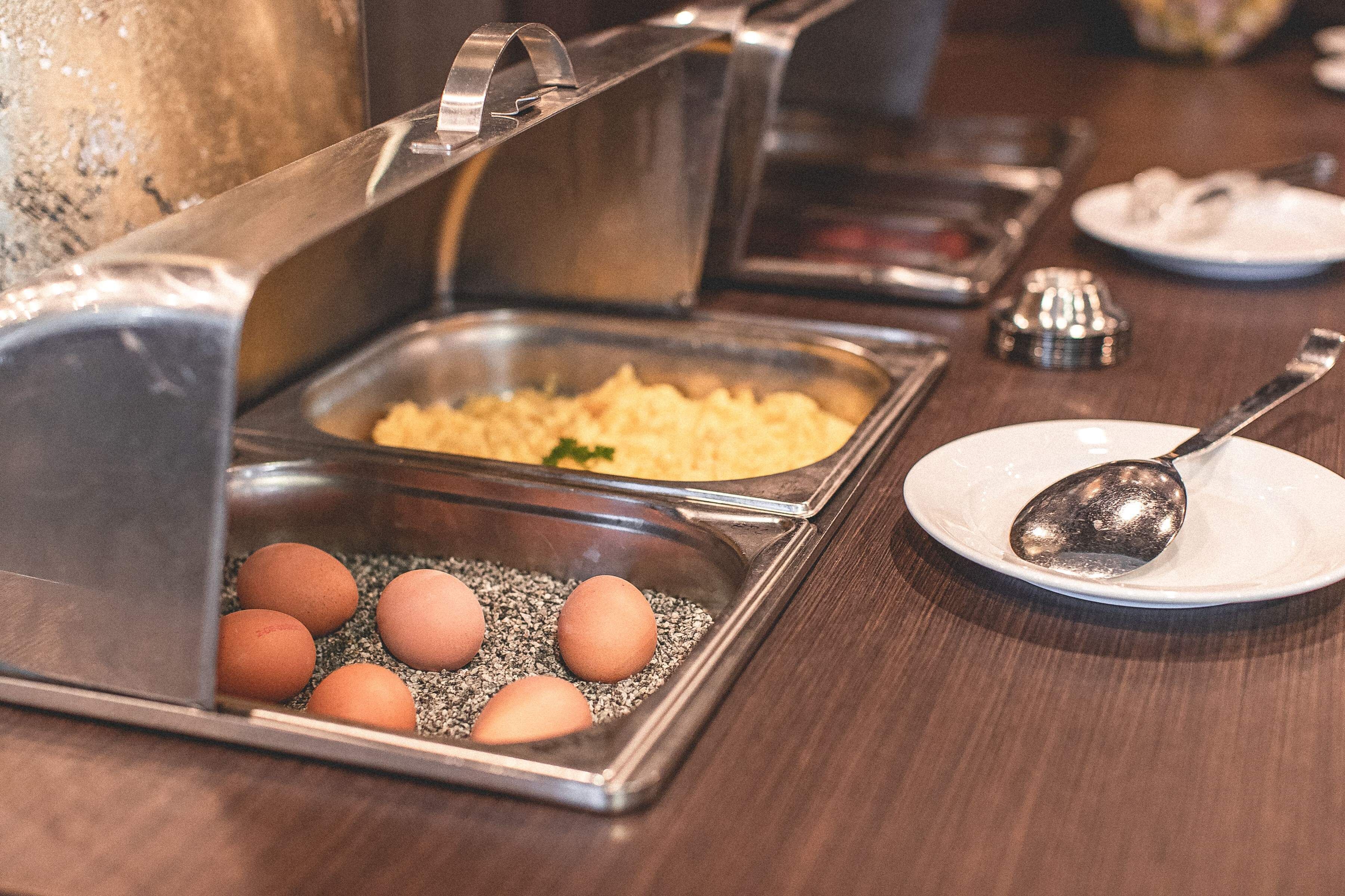 Una mesa de buffet con diversos alimentos y utensilios.