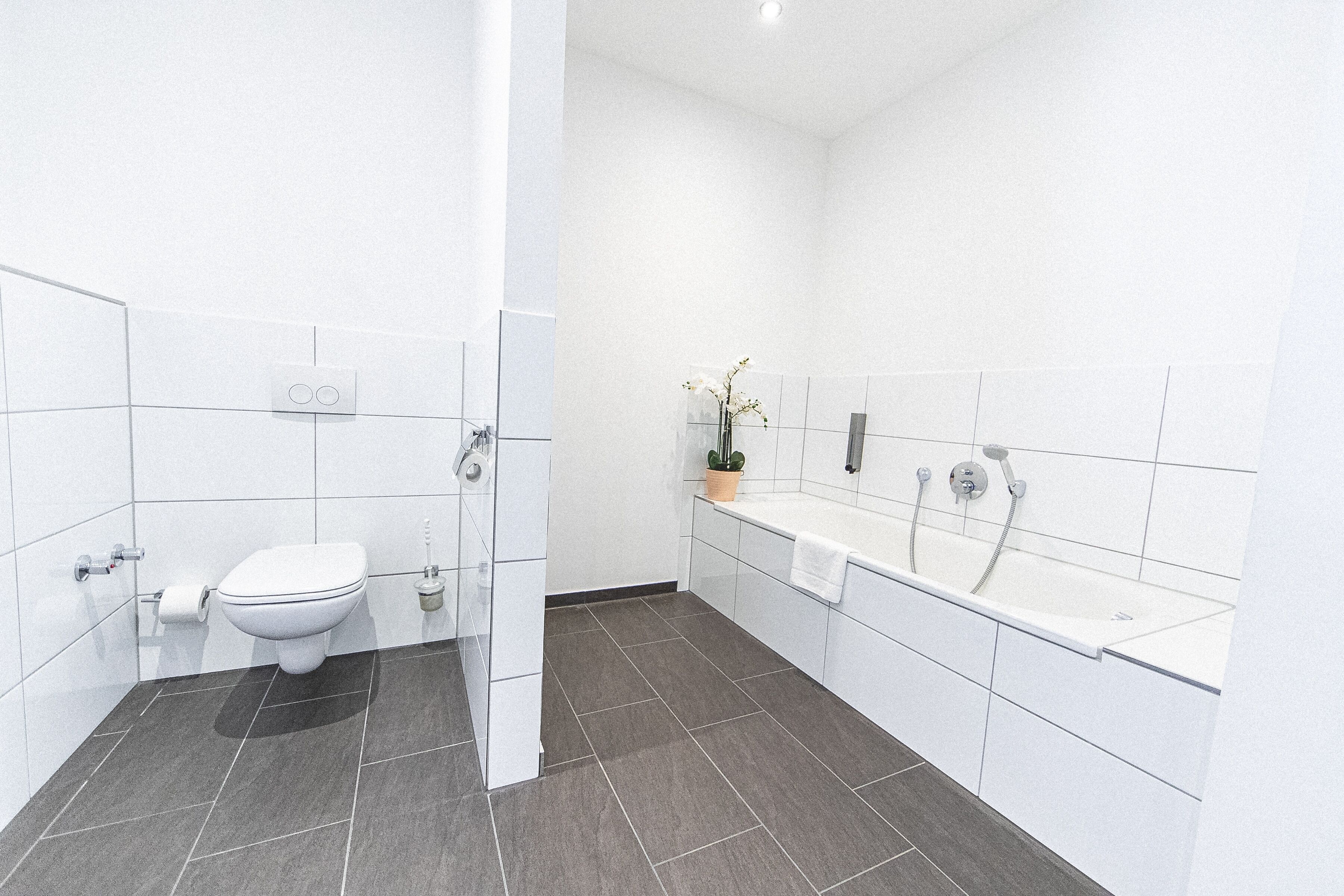 A modern bathroom with a toilet, sink, and bathtub.