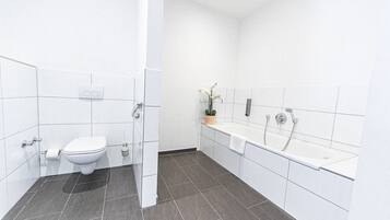 A modern bathroom with a toilet, sink, and bathtub.