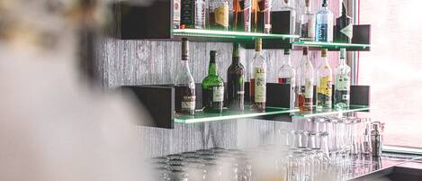 A bar area with shelves of liquor bottles and glasses.