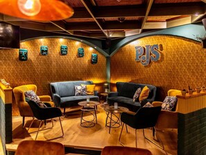 A cozy lounge area with sofas and chairs, a coffee table, and a wall with a 'PJS' sign. - Mercure Hotel Riesa Dresden Elbland (Riesa)
