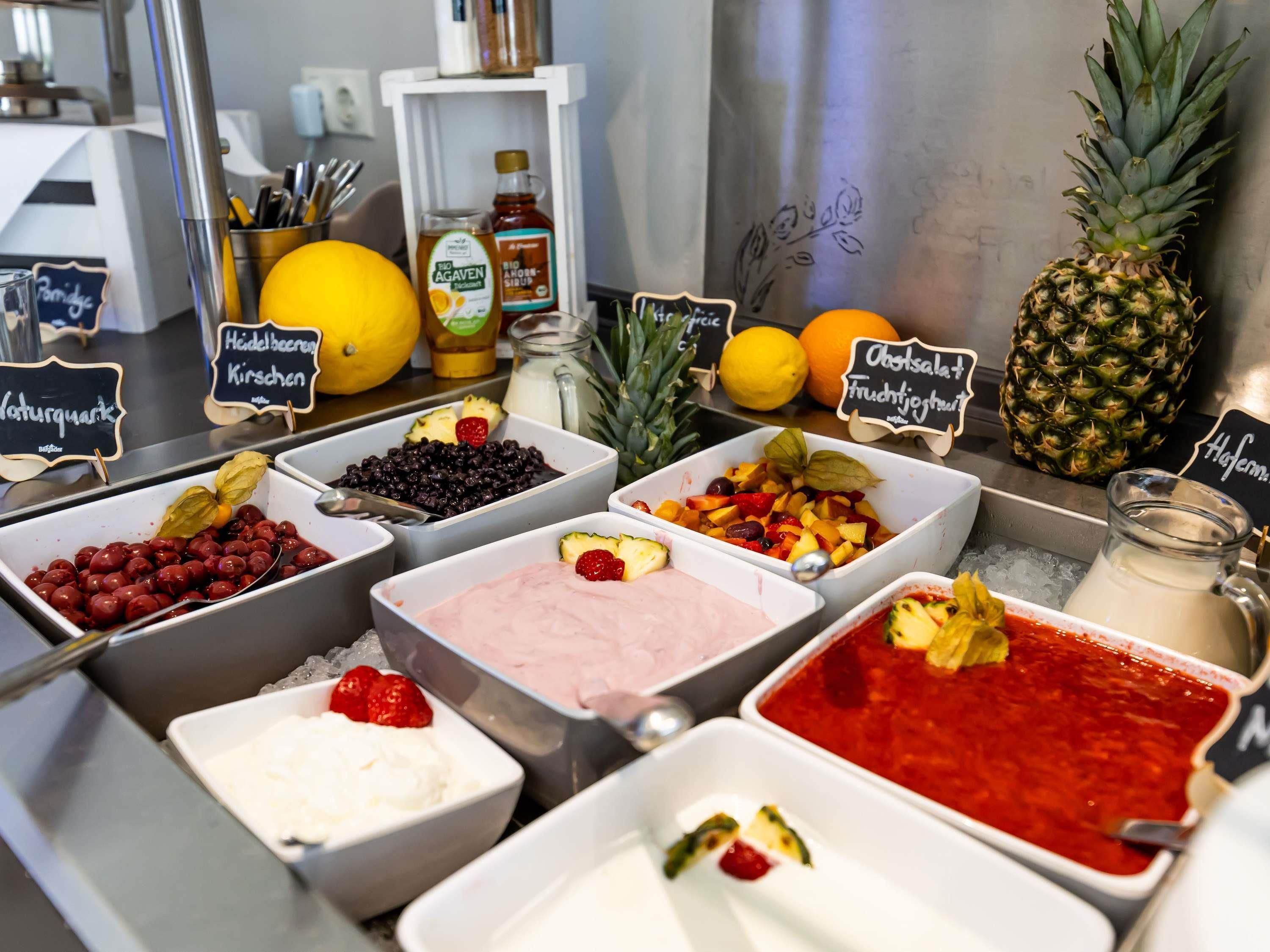 A buffet with various food options including fruits, berries, and different types of spreads.
