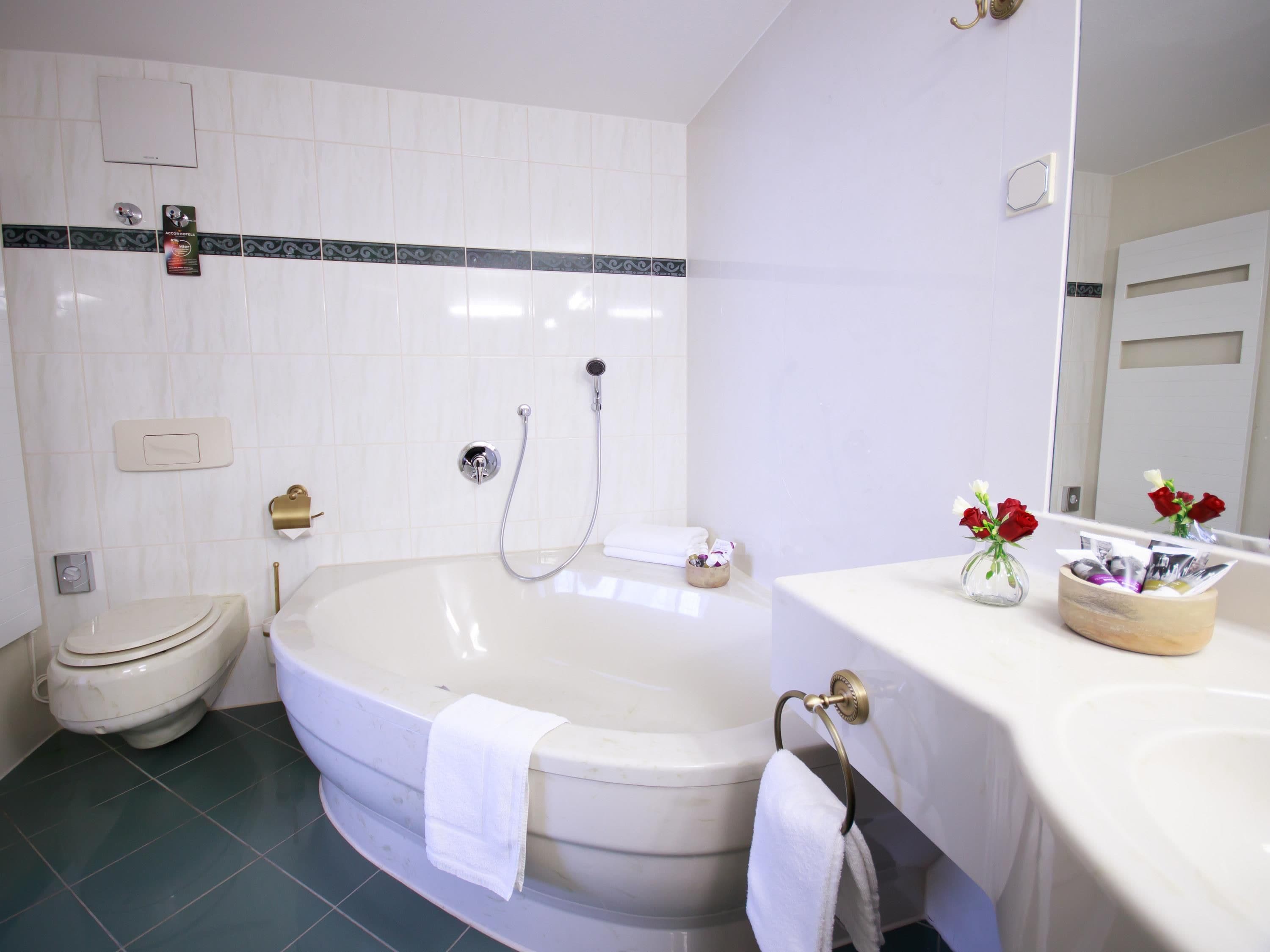 Ein Badezimmer mit Badewanne, Toilette und Waschbecken.