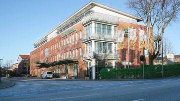 A modern hotel with a brick facade, large windows, and a covered entrance.