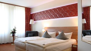 Una habitación de hotel con una cama grande, dos mesitas de noche, un espejo y un panel decorativo en la pared.
