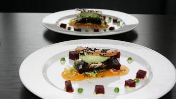 Deux assiettes blanches contenant de la nourriture, posées sur une table sombre.
