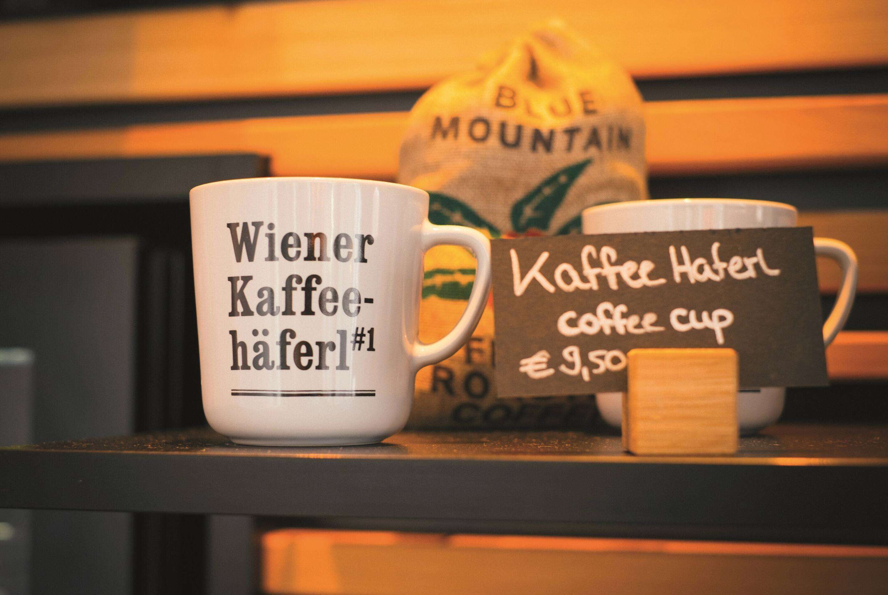Two coffee cups with text, one labeled "Wiener Kaffee-Häferl" and the other "Kaffee Hafterl coffee cup €9.50".