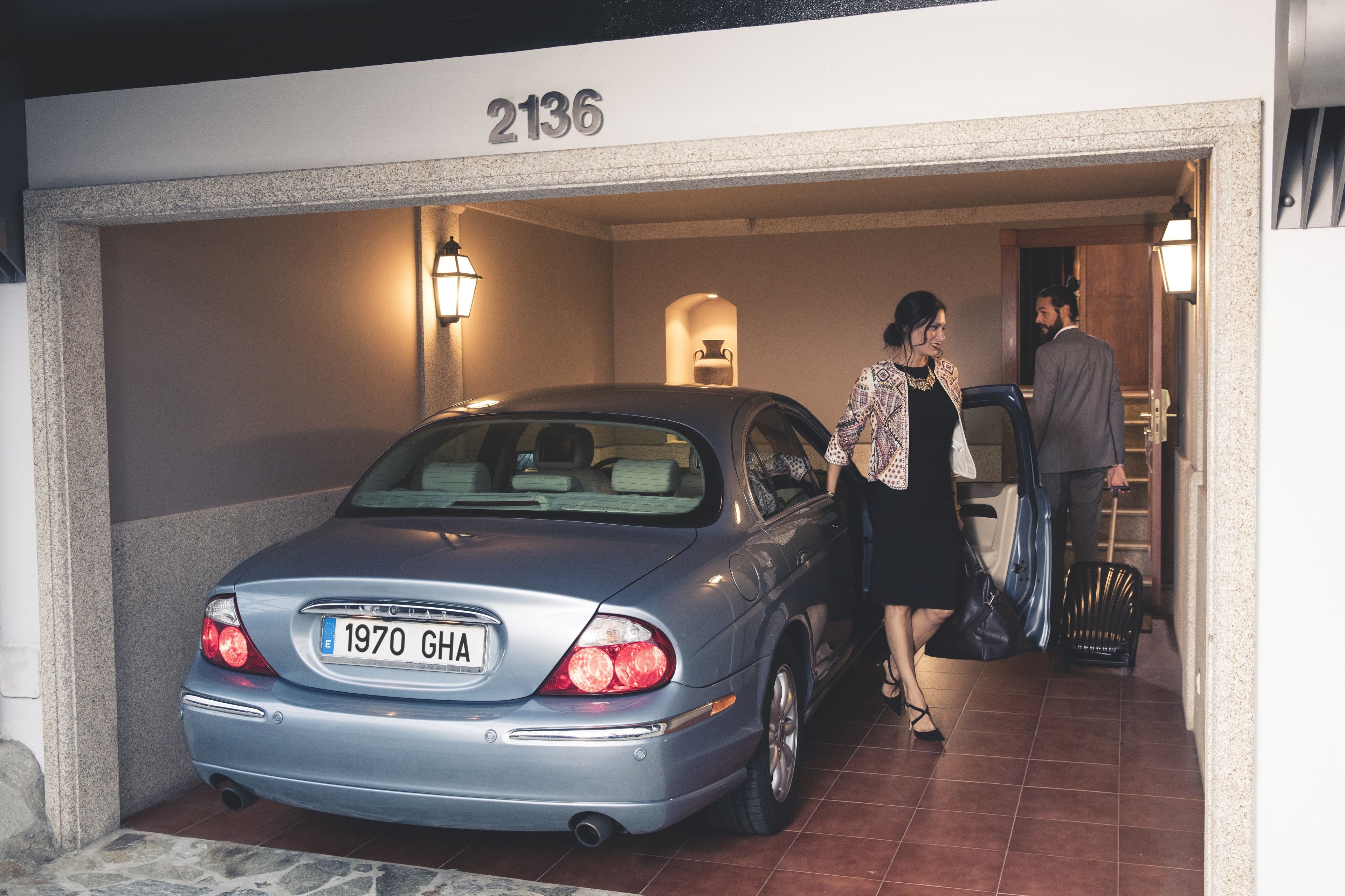 A car parked in a garage with a number 2136 above it.