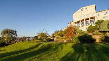 A large building with a classical architectural style, surrounded by well-maintained lawns and trees.