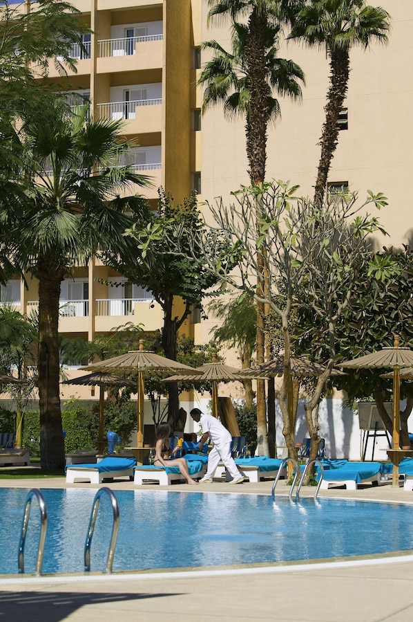 Una piscina al aire libre, sombrillas