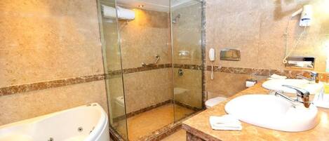 A modern bathroom with a glass-enclosed shower, a freestanding bathtub, and a marble vanity with a sink and mirror.