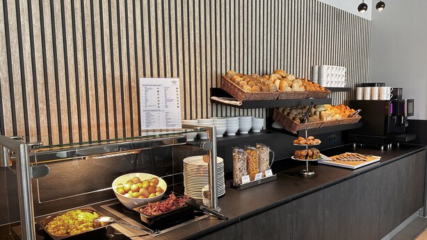 A buffet setup with various food items and a coffee machine.