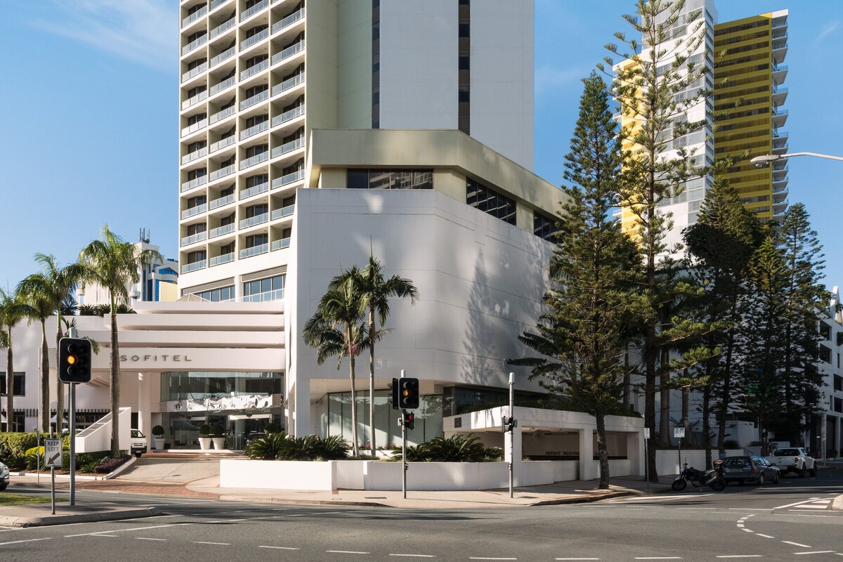 Un grand hôtel moderne, facilement reconnaissable à son imposante enseigne « SOFITEL », qui se distingue par sa façade blanche et épurée, ainsi que par un motif de bandes verticales.