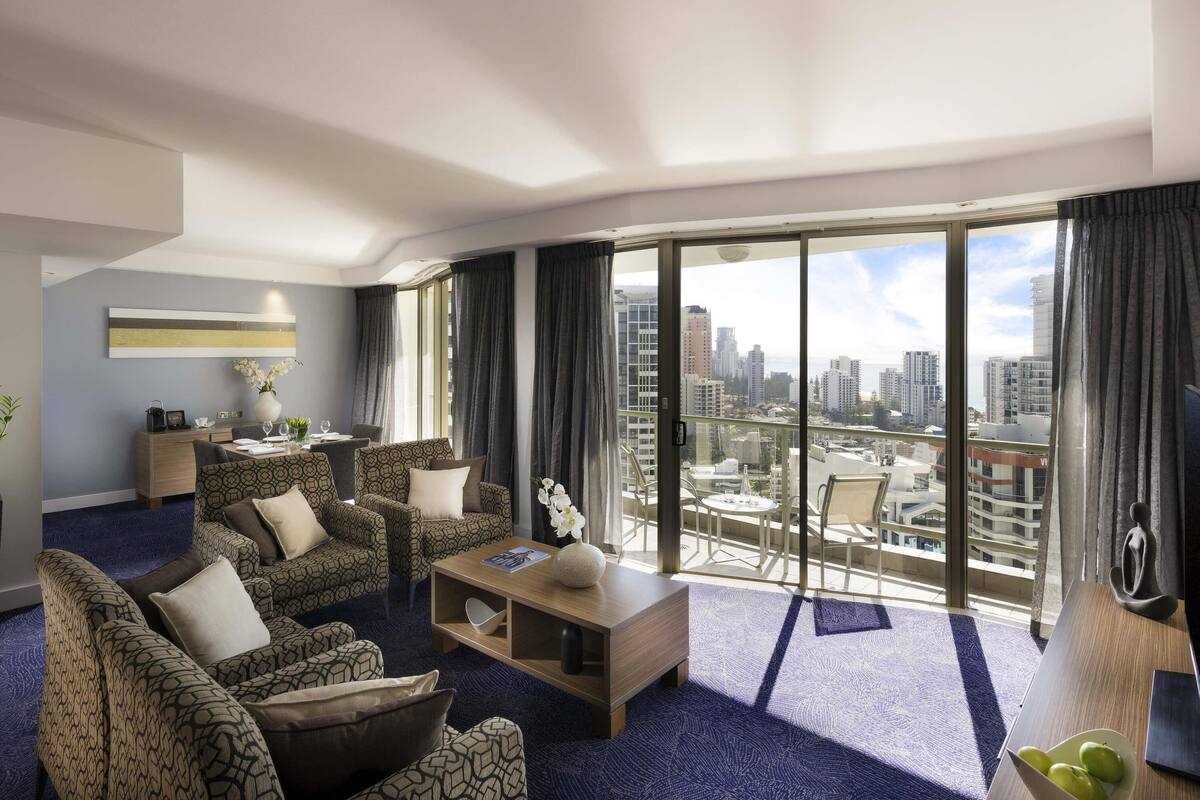Un salon moderne avec vue sur la ville, un coin repas et une grande fenêtre.