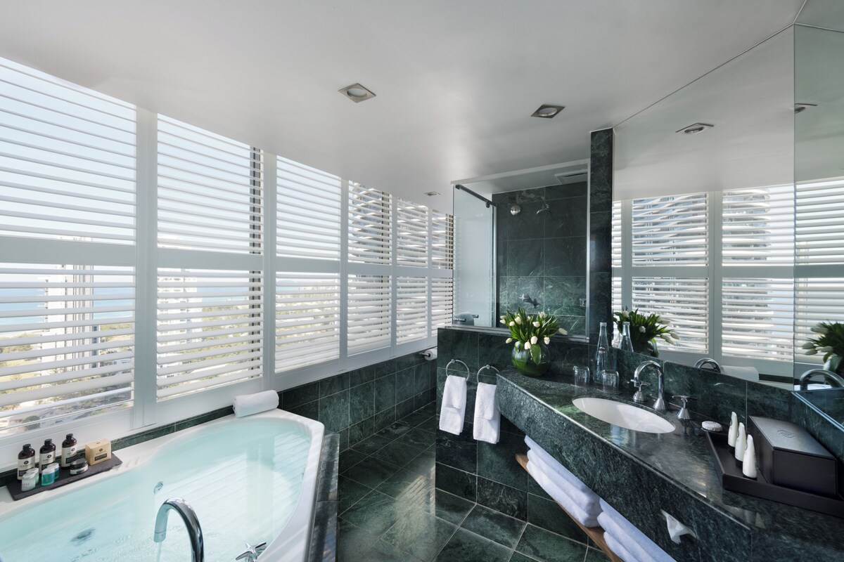 Une salle de bain moderne avec une grande baignoire, deux lavabos et un espace douche.