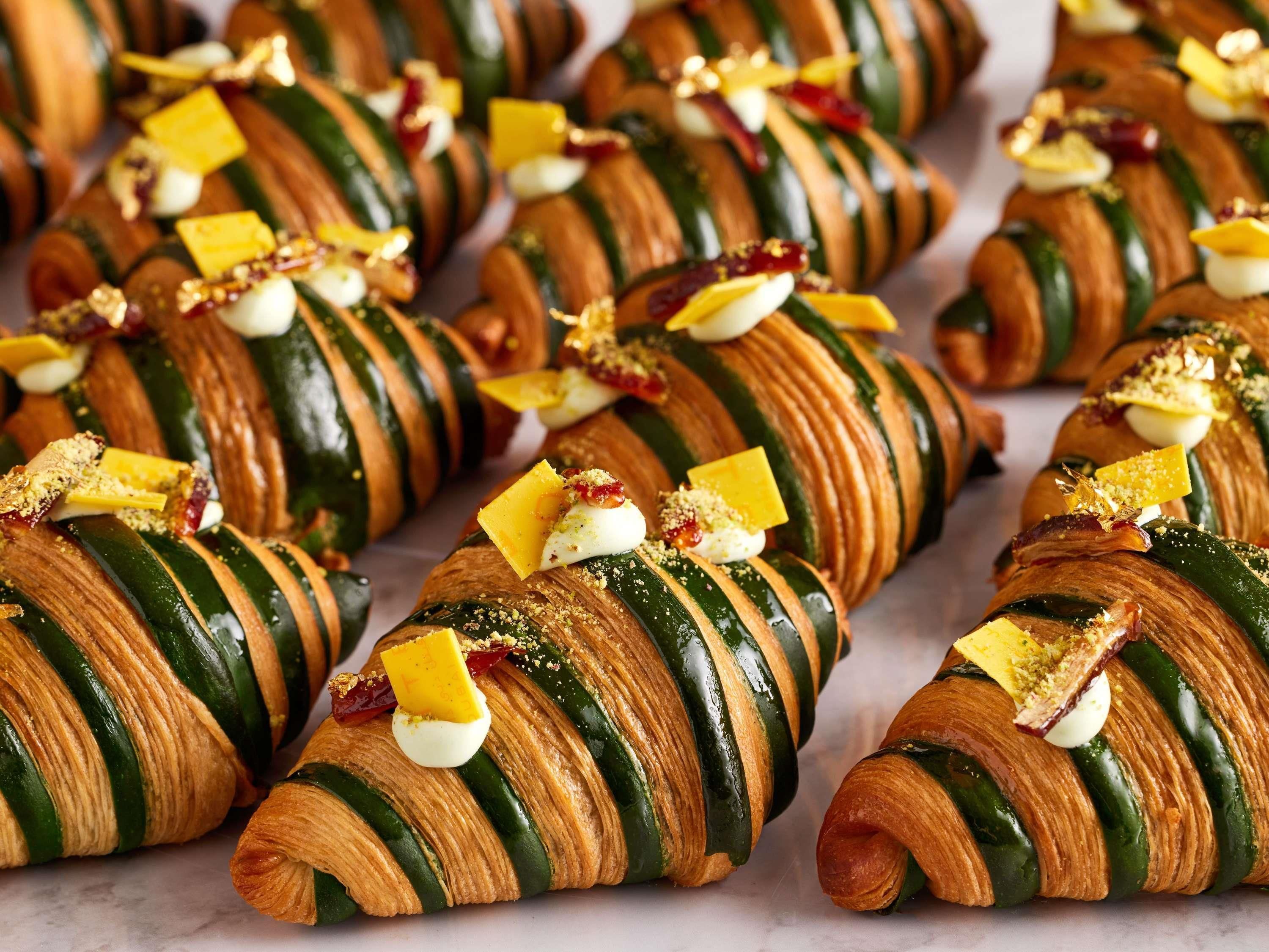 A row of croissants with various toppings.