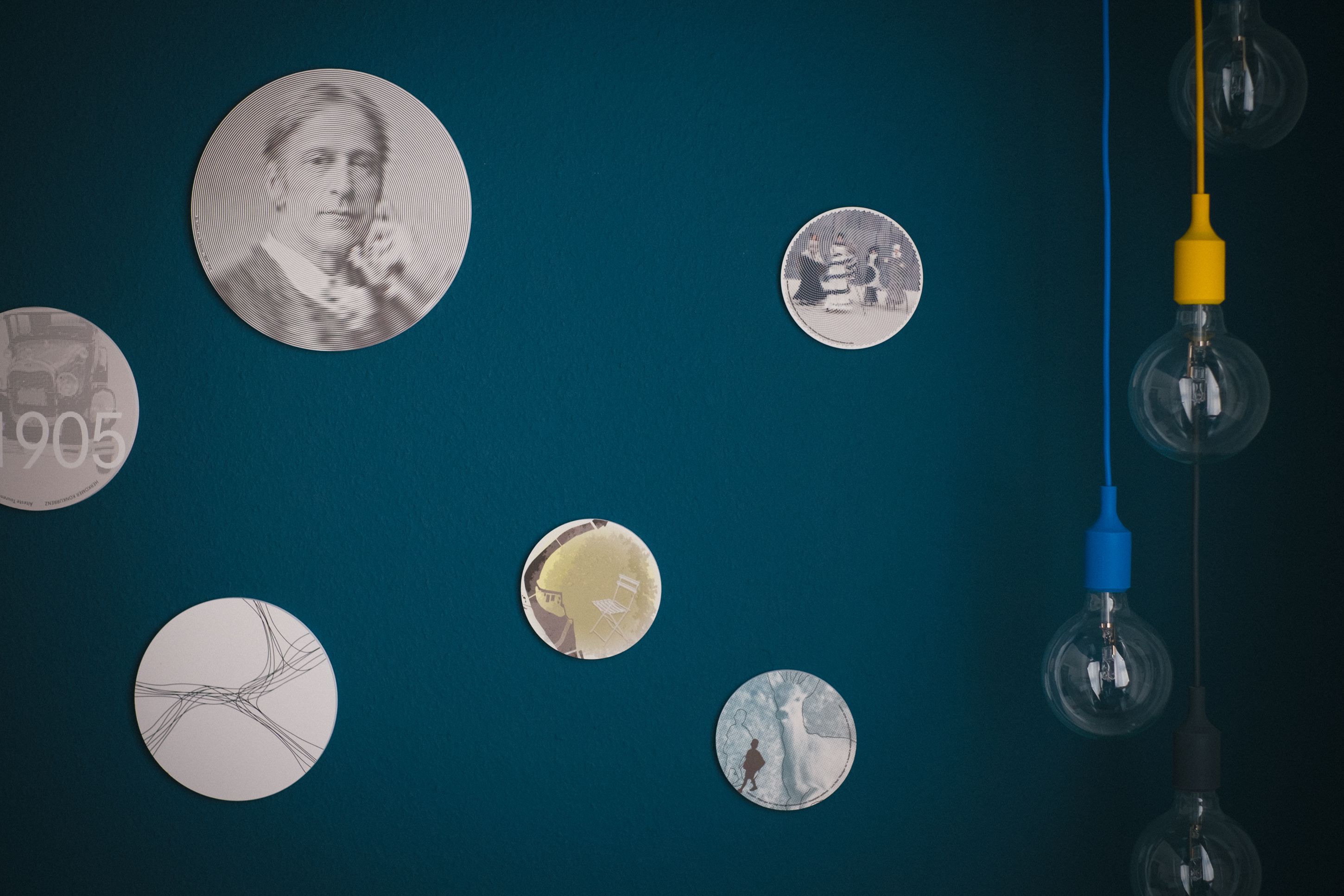 Un mur orné d’objets circulaires, dont une vieille pièce de monnaie et une ampoule.