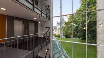 A multi-level interior with a glass railing overlooking a courtyard.