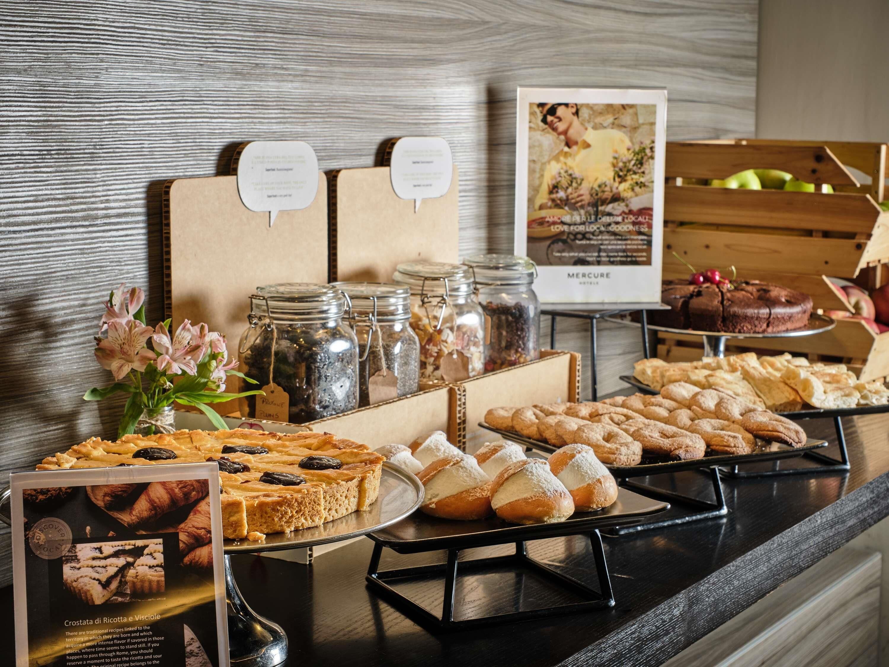 Un buffet proposant une variété de produits de boulangerie, notamment des tartes et des pâtisseries, ainsi que des pots de confitures.