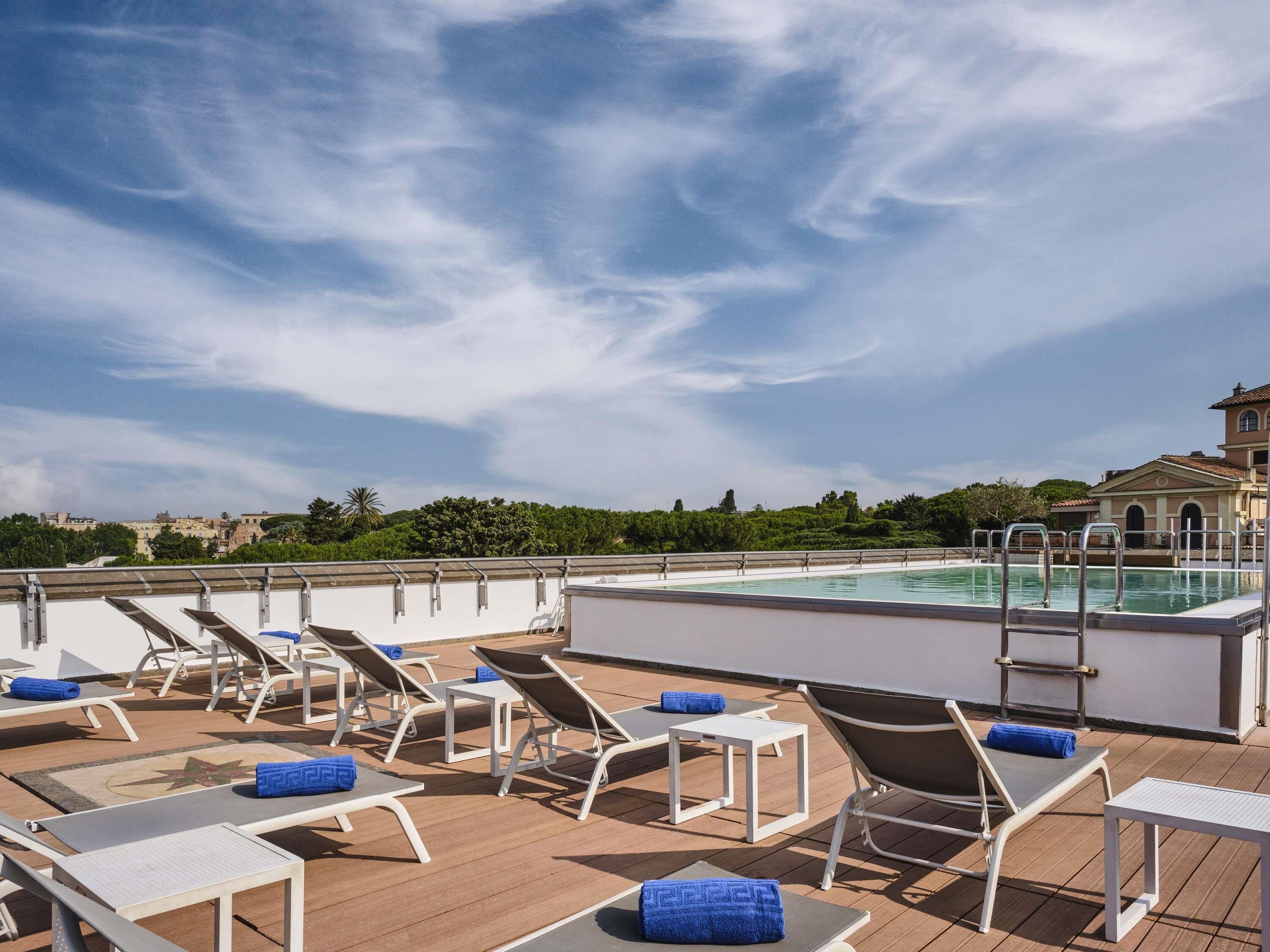 A rooftop pool area with sun loungers and a pool.