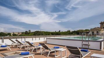 A rooftop pool area with sun loungers and a pool.