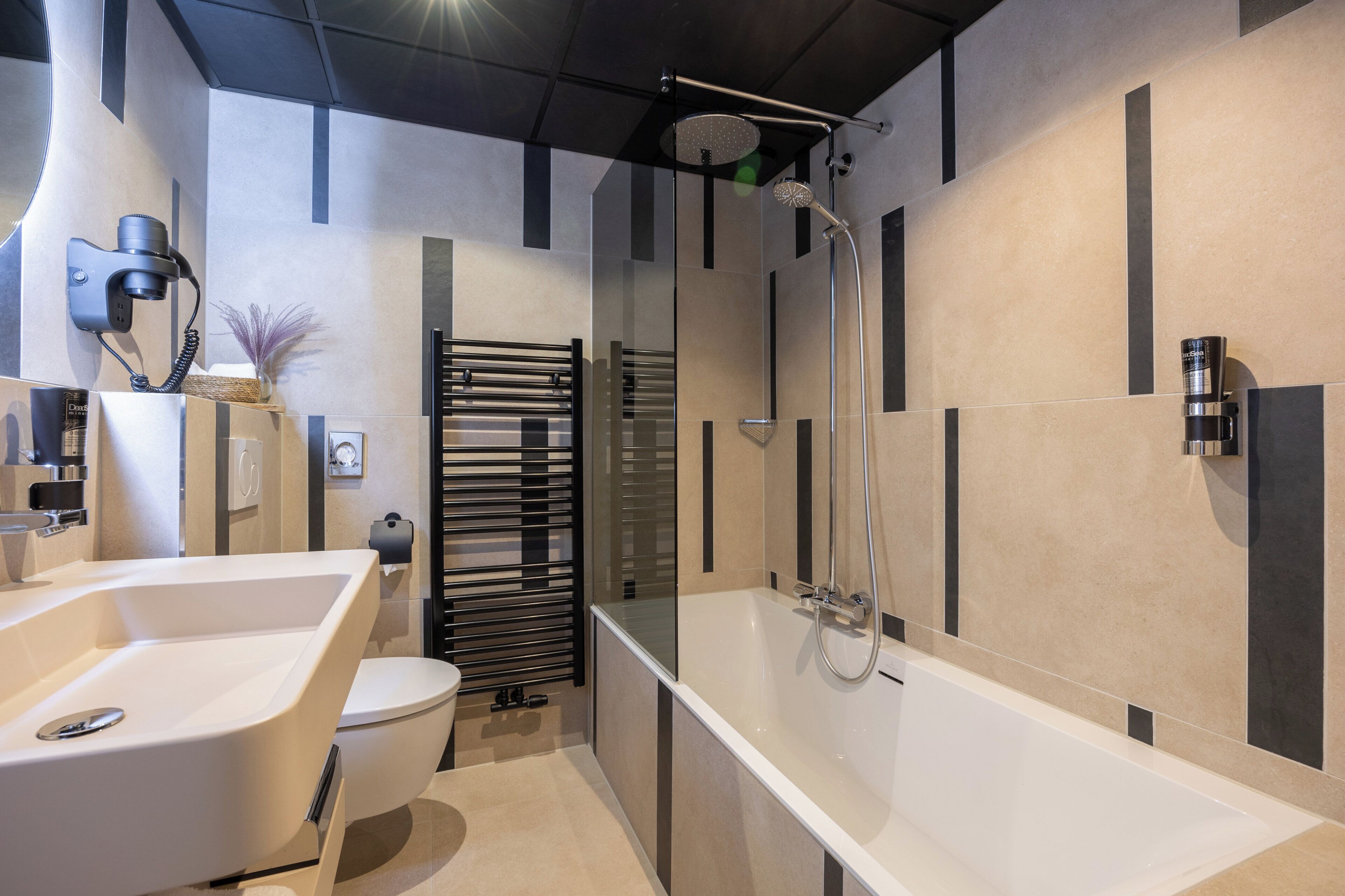 Een moderne badkamer met een vrijstaand bad, een toilet en een douchehoek.