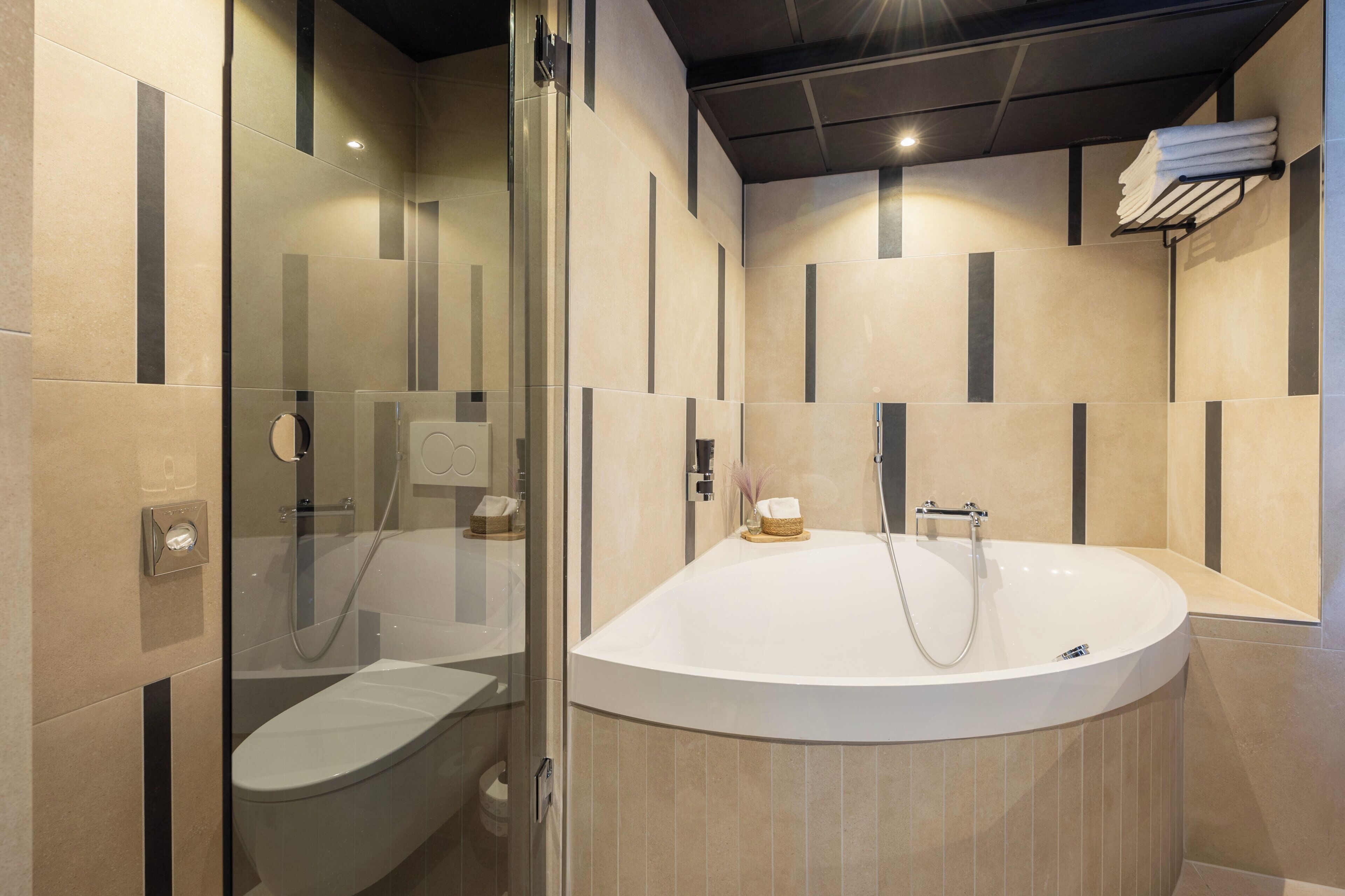 A modern bathroom with a glass-enclosed shower, a freestanding bathtub, and a toilet.