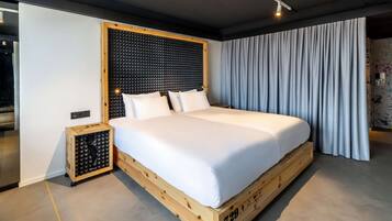 Un dormitorio moderno con una cama plataforma de madera, un cabecero insonorizado y un ventanal con cortinas.