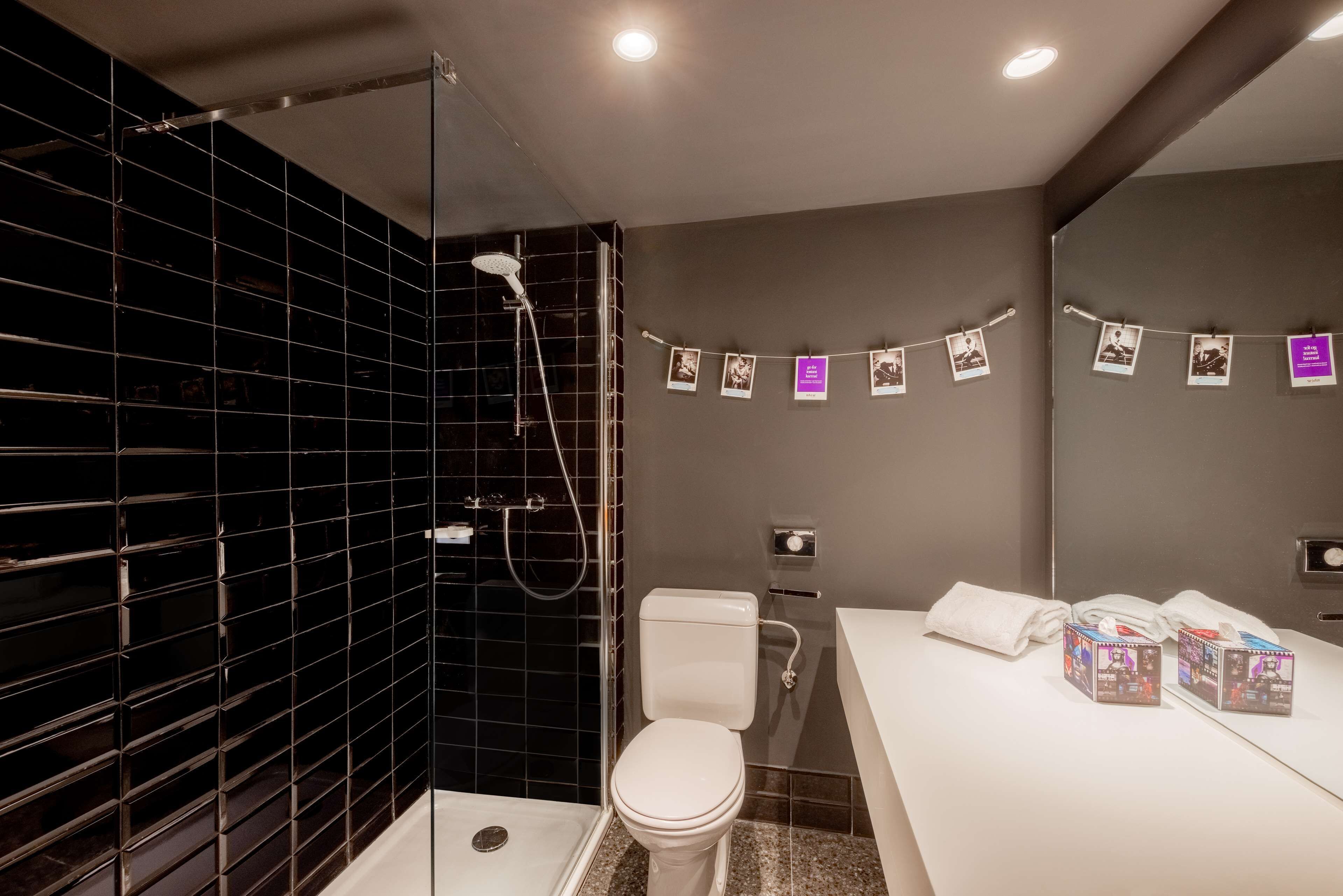 A modern bathroom with a shower, toilet, and vanity.