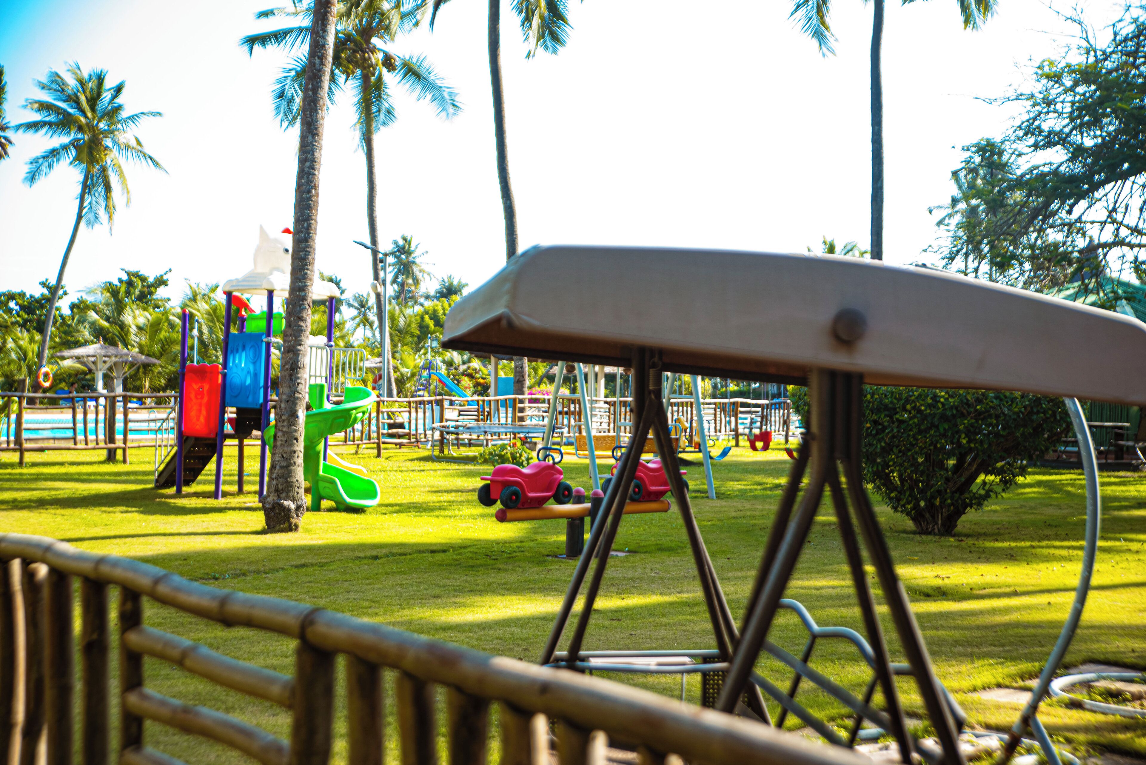 Un parque infantil con columpios, toboganes y una estructura para escalar.