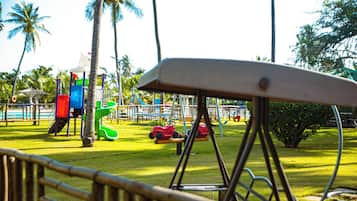 Un parque infantil con columpios, toboganes y una estructura para escalar.