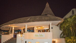 Un bâtiment doté d’un toit conique et d’une enseigne sur laquelle on peut lire « Sika Sika ».