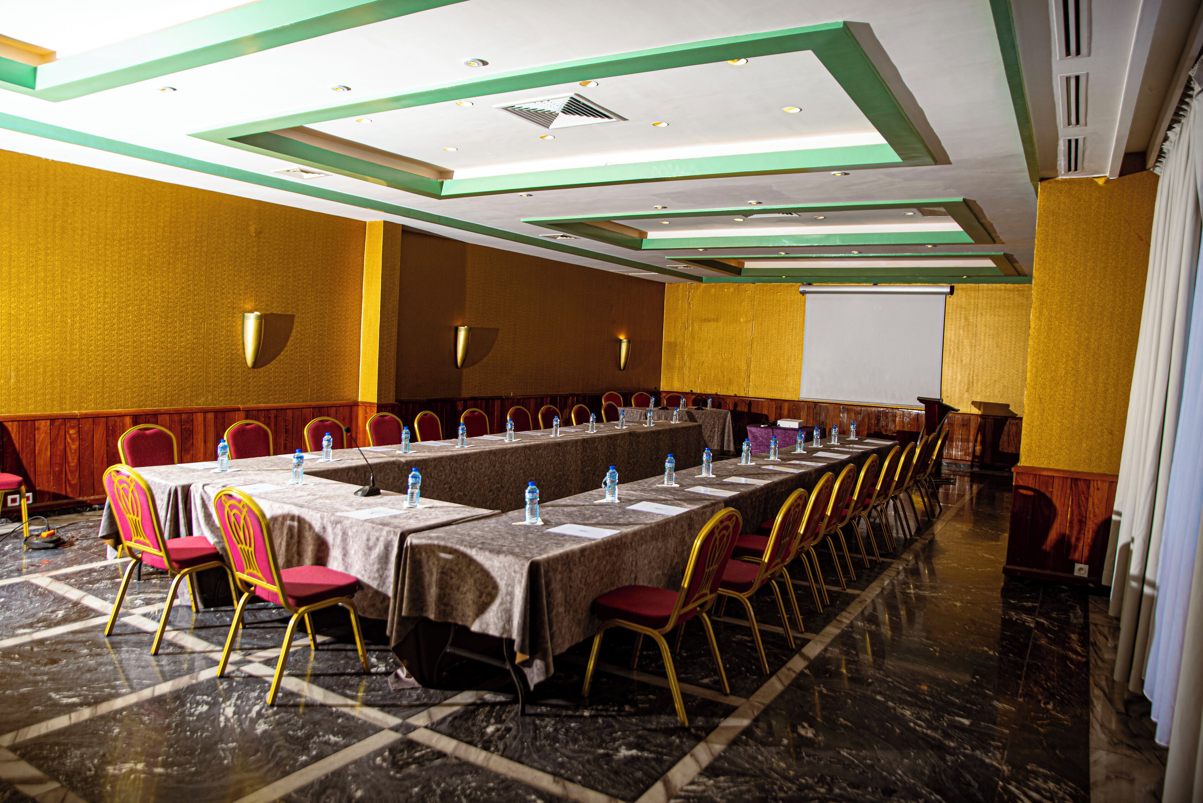 A conference room with a long table, chairs, and water bottles.