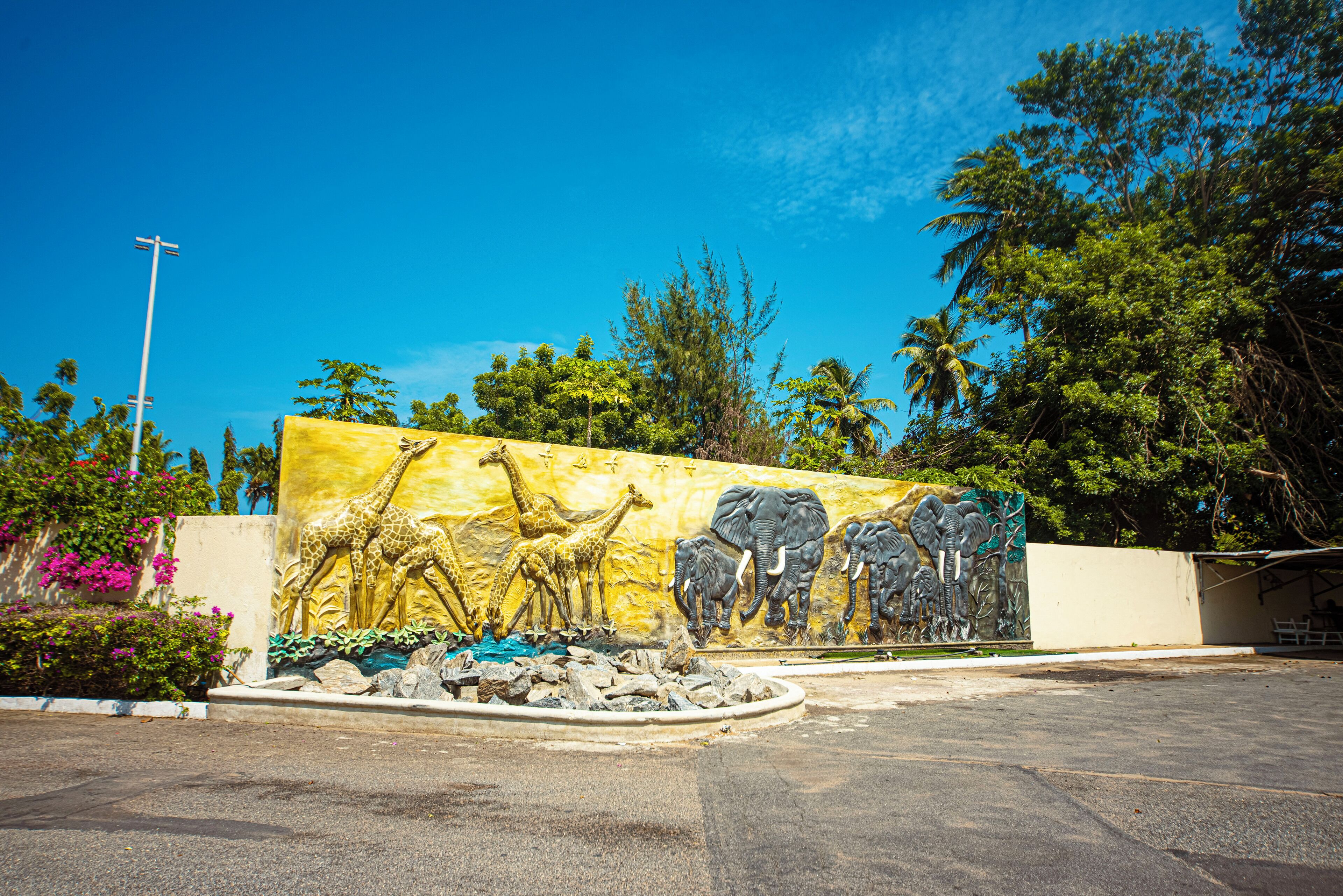 A mural of giraffes and elephants on a wall.