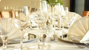 Una mesa dispuesta con varias copas de vino, platos y cubiertos, lo que sugiere un ambiente de comedor formal.