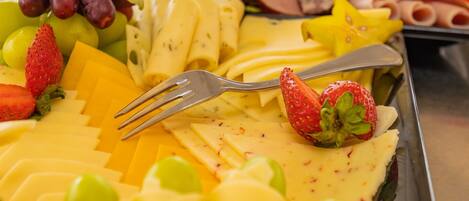 A buffet with various fruits, cheeses, and meats.